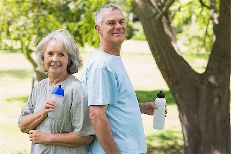Portrait of a smiling mature couple standing with water bottles at the park Stock Photo - Budget Royalty-Free & Subscription, Code: 400-07337063