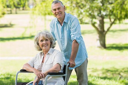 simsearch:400-07337135,k - Portrait of a smiling mature man with woman sitting in wheel chair at the park Stock Photo - Budget Royalty-Free & Subscription, Code: 400-07337096