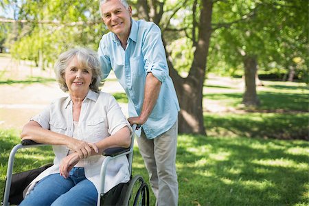 simsearch:400-07337135,k - Portrait of a smiling mature man with woman sitting in wheel chair at the park Stock Photo - Budget Royalty-Free & Subscription, Code: 400-07337099