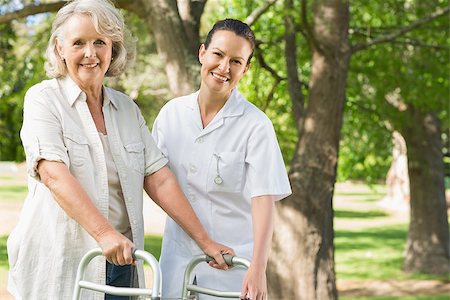 Smiling young female assisting mature woman with walker at the park Stock Photo - Budget Royalty-Free & Subscription, Code: 400-07337143