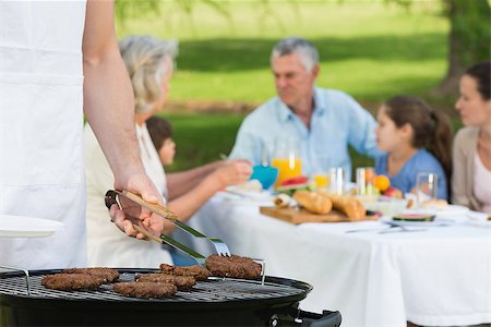 simsearch:649-07436855,k - Close-up of barbecue grill with extended family having lunch in the park Stockbilder - Microstock & Abonnement, Bildnummer: 400-07337158