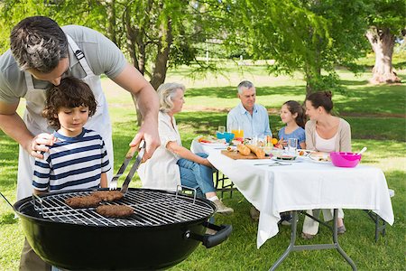 simsearch:649-07436855,k - Father and son at barbecue grill with extended family having lunch in the park Stockbilder - Microstock & Abonnement, Bildnummer: 400-07337161