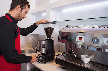 sfregare - Handsome barista grinding coffee beans in a cafe Fotografie stock - Microstock e Abbonamento, Codice: 400-07337210