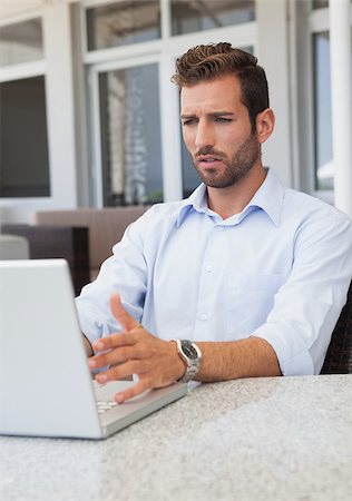 simsearch:400-04168729,k - Stressed businessman working on laptop at table in outdoor patio of restaurant Stock Photo - Budget Royalty-Free & Subscription, Code: 400-07337269