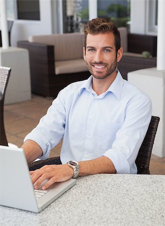 simsearch:400-04168729,k - Smiling businessman working on laptop at table in outdoor patio of restaurant Stock Photo - Budget Royalty-Free & Subscription, Code: 400-07337270