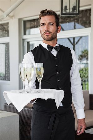 simsearch:6109-07601183,k - Handsome waiter holding tray of champagne in the patio of restaurant Foto de stock - Super Valor sin royalties y Suscripción, Código: 400-07337346