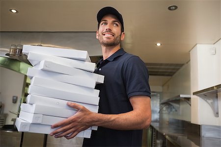 pizza restaurant - Smiling pizza delivery man holding many pizza boxes in a commercial kitchen Stock Photo - Budget Royalty-Free & Subscription, Code: 400-07337356