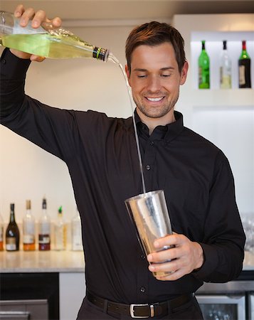 pouring cocktail shaker into glass - Happy bartender preparing a cocktail at the bar Stock Photo - Budget Royalty-Free & Subscription, Code: 400-07337376