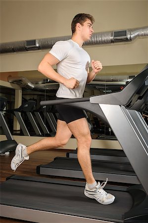 starush (artist) - young handsome man running at treadmill in gym Stockbilder - Microstock & Abonnement, Bildnummer: 400-07337620