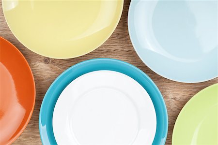 simsearch:400-07331603,k - Colorful plates and saucers over wooden table background. View from above Foto de stock - Super Valor sin royalties y Suscripción, Código: 400-07337809