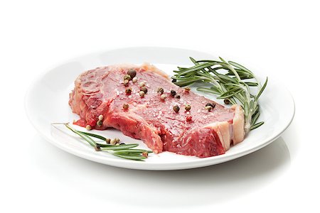Raw sirloin steak with rosemary and spices on plate. Isolated on white background Stock Photo - Budget Royalty-Free & Subscription, Code: 400-07337848