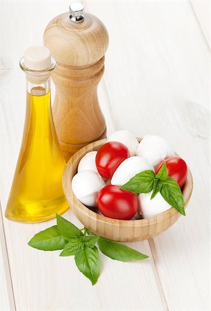 simsearch:400-08071423,k - Mozzarella cheese with cherry tomatoes, basil and olive oil with pepper shaker on white wood table Foto de stock - Royalty-Free Super Valor e Assinatura, Número: 400-07337878
