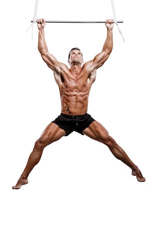 flying trapeze - Muscle man in studio making elevations, isolated over a white background Stock Photo - Budget Royalty-Free & Subscription, Code: 400-07338162