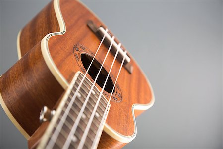 simsearch:400-07505739,k - Close-up shot of ukulele guitar, studio shot on grey background, selective focus Stock Photo - Budget Royalty-Free & Subscription, Code: 400-07338921