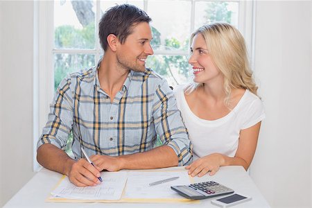 Happy young couple with financial documents and calculator sitting at home Stock Photo - Budget Royalty-Free & Subscription, Code: 400-07339114