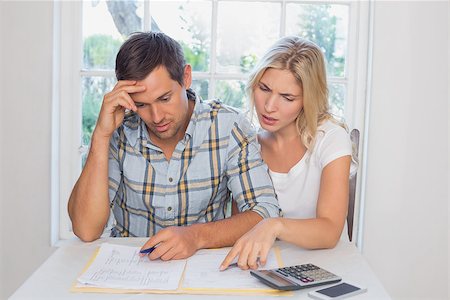 Worried young couple with financial documents and calculator sitting at home Stock Photo - Budget Royalty-Free & Subscription, Code: 400-07339116