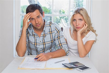 Worried young couple with financial documents and calculator sitting at home Stock Photo - Budget Royalty-Free & Subscription, Code: 400-07339118