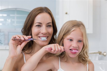 Close-up of mother and daughter brushing teeth in the bathroom Stock Photo - Budget Royalty-Free & Subscription, Code: 400-07339460