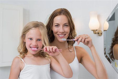Portrait up of mother and daughter brushing teeth in the bathroom Stock Photo - Budget Royalty-Free & Subscription, Code: 400-07339536