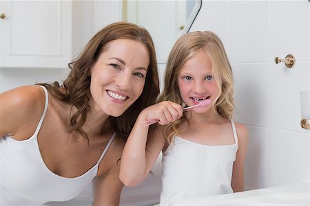 Portrait of mother with daughter brushing teeth in the bathroom Stock Photo - Budget Royalty-Free & Subscription, Code: 400-07339540