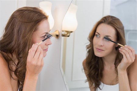 photography of someone putting on makeup in mirror - Side view of a beautiful young woman applying mascara in the bathroom at home Stock Photo - Budget Royalty-Free & Subscription, Code: 400-07339543