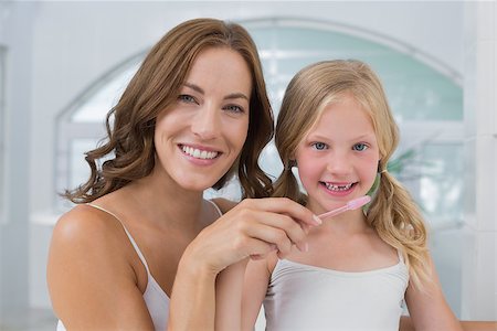 Close-up of mother with daughter brushing teeth in the bathroom Stock Photo - Budget Royalty-Free & Subscription, Code: 400-07339649