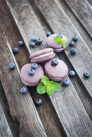 Violet french macarons with blueberry and mint on wooden table Stockbilder - Microstock & Abonnement, Bildnummer: 400-07330062