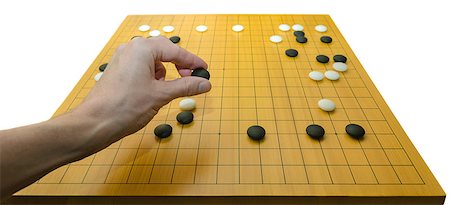 A hand placing a stone on a go board. Go is a traditional asian board game. It is supposed to be one of the oldest games in the world. Foto de stock - Royalty-Free Super Valor e Assinatura, Número: 400-07330528