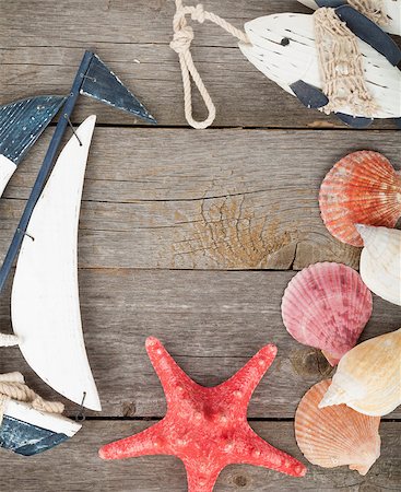 starfish beach nobody - Toy sailboat and fish with seashells and starfish on a wooden background with copy space Stock Photo - Budget Royalty-Free & Subscription, Code: 400-07331486