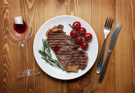 Sirloin steak with rosemary and cherry tomatoes on a plate with wine. View from above Stock Photo - Budget Royalty-Free & Subscription, Code: 400-07331670