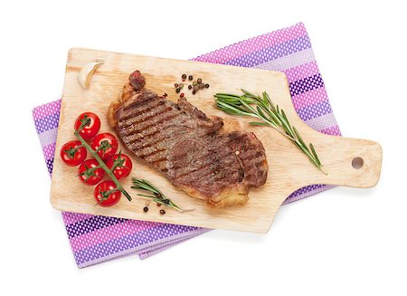 steak and fries - Sirloin steak with rosemary and cherry tomatoes on a cutting board. Isolated on white background. View from above Photographie de stock - Aubaine LD & Abonnement, Code: 400-07331673