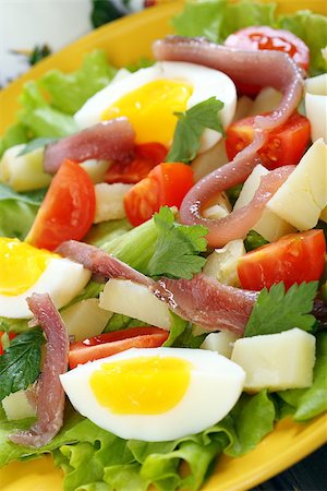potato salad yellow - Salad with eggs, cherry tomatoes and anchovies on a yellow plate. Stock Photo - Budget Royalty-Free & Subscription, Code: 400-07332362