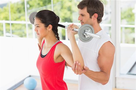 simsearch:400-06801591,k - Male trainer helping young fit woman to lift the barbell in the gym Stock Photo - Budget Royalty-Free & Subscription, Code: 400-07333066