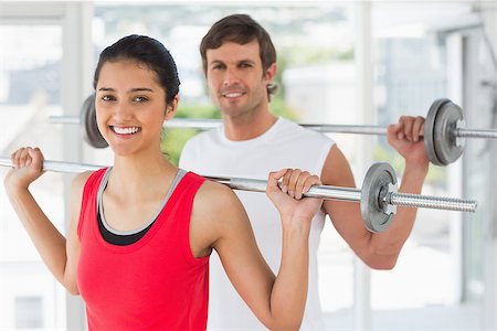 simsearch:400-06801591,k - Portrait of a fit young man and woman lifting barbells in the gym Foto de stock - Super Valor sin royalties y Suscripción, Código: 400-07333069