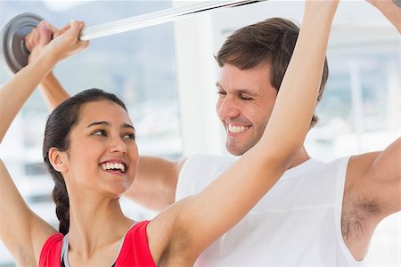 simsearch:400-07333355,k - Happy male trainer helping young fit woman to lift the barbell in the gym Stock Photo - Budget Royalty-Free & Subscription, Code: 400-07333063