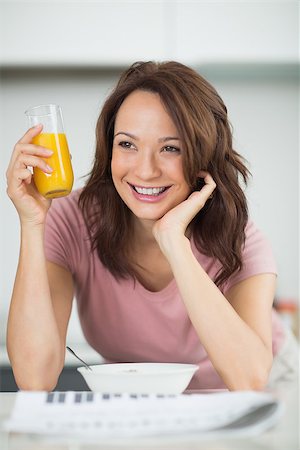 simsearch:400-06871178,k - Smiling young woman with a bowl of cereals, orange juice and newspaper in the kitchen at home Stock Photo - Budget Royalty-Free & Subscription, Code: 400-07333453