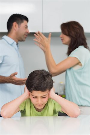 Sad young boy covering ears while parents quarreling in the kitchen at home Stock Photo - Budget Royalty-Free & Subscription, Code: 400-07333590