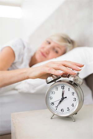simsearch:614-02613098,k - Blurred sleepy mature woman extending hand to alarm clock in bed at home Stockbilder - Microstock & Abonnement, Bildnummer: 400-07333709