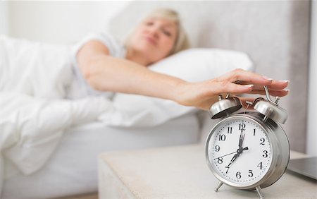 simsearch:614-02613098,k - Blurred sleepy mature woman extending hand to alarm clock in bed at home Stockbilder - Microstock & Abonnement, Bildnummer: 400-07333711