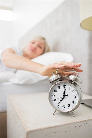 simsearch:614-02613098,k - Blurred sleepy mature woman extending hand to alarm clock in bed at home Stockbilder - Microstock & Abonnement, Bildnummer: 400-07333712
