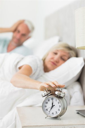 simsearch:614-02613098,k - Blurred sleepy mature woman extending hand to alarm clock in bed at home Stockbilder - Microstock & Abonnement, Bildnummer: 400-07333741