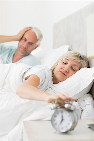 simsearch:614-02613098,k - Man covering ears while woman extending hand to alarm clock in bed at home Stockbilder - Microstock & Abonnement, Bildnummer: 400-07333742
