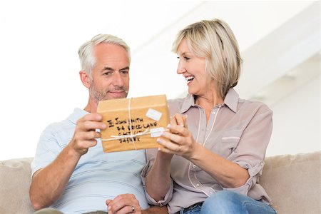 simsearch:6109-07601570,k - Portrait of a smiling woman surprising mature man with a gift on sofa at home Stockbilder - Microstock & Abonnement, Bildnummer: 400-07333889