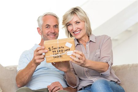 simsearch:6109-07601570,k - Portrait of a smiling woman surprising mature man with a gift on sofa at home Stockbilder - Microstock & Abonnement, Bildnummer: 400-07333890