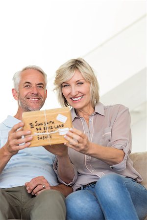 simsearch:6109-07601570,k - Portrait of a smiling woman surprising mature man with a gift on sofa at home Stockbilder - Microstock & Abonnement, Bildnummer: 400-07333891