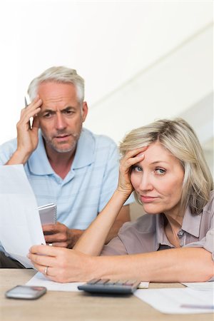 Tensed mature man and woman with bills sitting on sofa at home Stock Photo - Budget Royalty-Free & Subscription, Code: 400-07333929