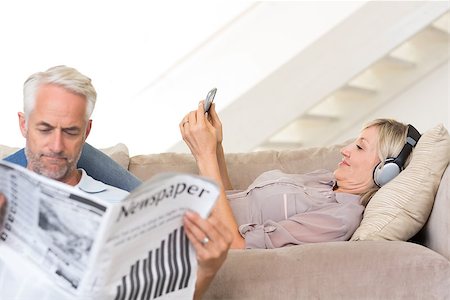 simsearch:400-07333928,k - Mature man reading newspaper while woman text messaging in the living room at home Stock Photo - Budget Royalty-Free & Subscription, Code: 400-07333940