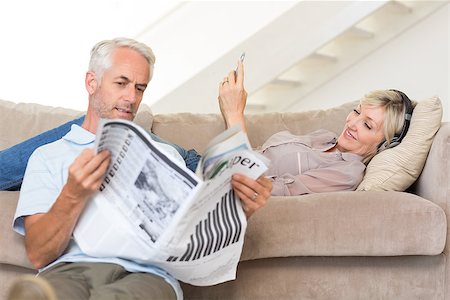 simsearch:400-07333928,k - Mature man reading newspaper while woman text messaging in the living room at home Stock Photo - Budget Royalty-Free & Subscription, Code: 400-07333941