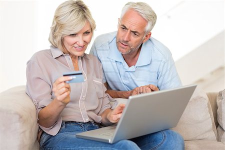 Casual mature couple doing online shopping through computer and credit card at home Stock Photo - Budget Royalty-Free & Subscription, Code: 400-07333971