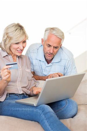 Casual mature couple doing online shopping through computer and credit card at home Stock Photo - Budget Royalty-Free & Subscription, Code: 400-07333972